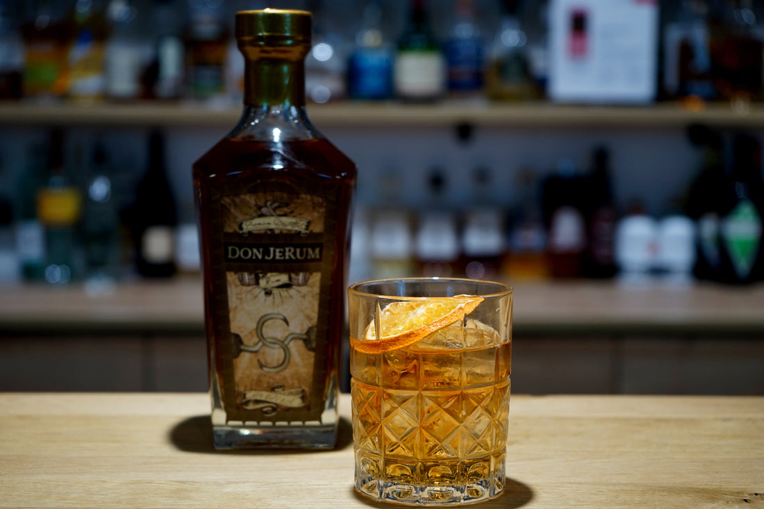 Rum Old Fashioned im Tumbler mit Orangenzeste