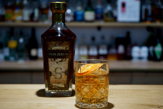 Rum Old Fashioned im Tumbler mit Orangenzeste